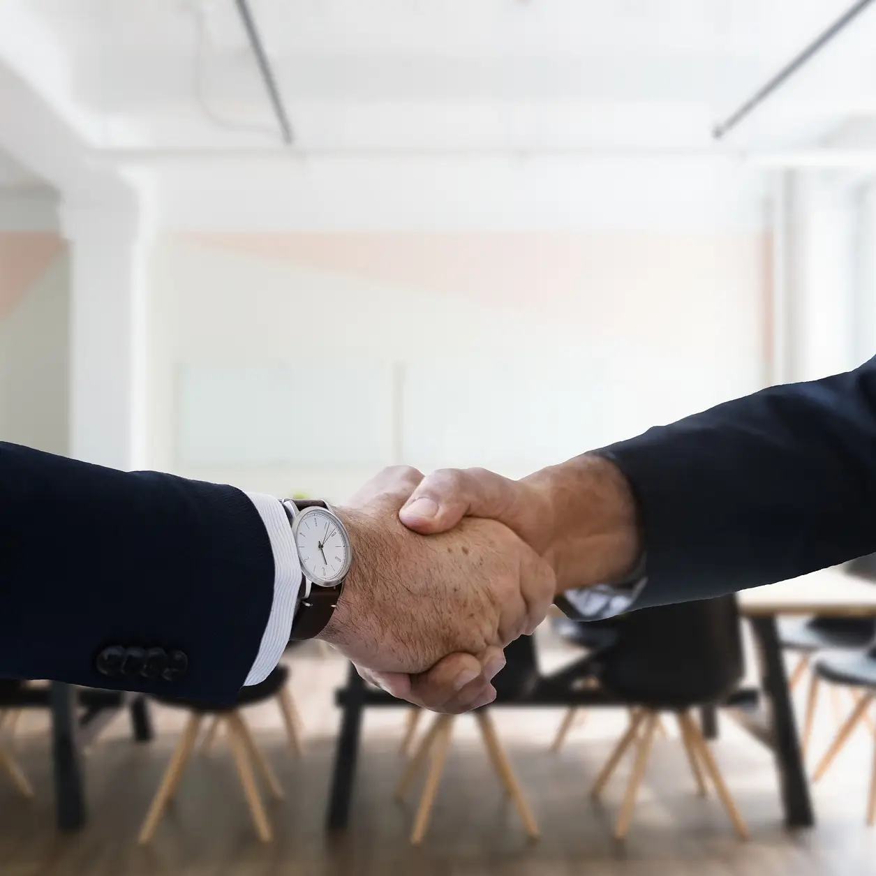 Dvije ruke se rukuju u prostoriji
